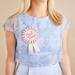The rosette worn by a girl in a blue dress.