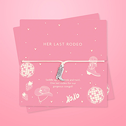 A bracelet with a cowboy boot charm in cute pink packaging. 